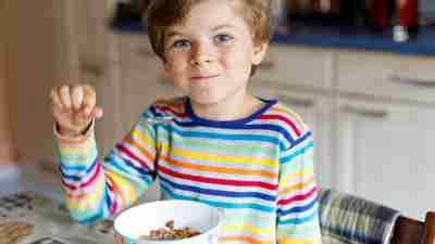 Boy with ADHD eating cereal — a quick breakfast to smooth the morning routine.
