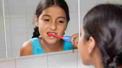 Child with ADHD brushing her teeth trying to avoid the morning rush