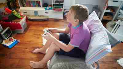 A blond boy playing video games to help with ADHD symptoms